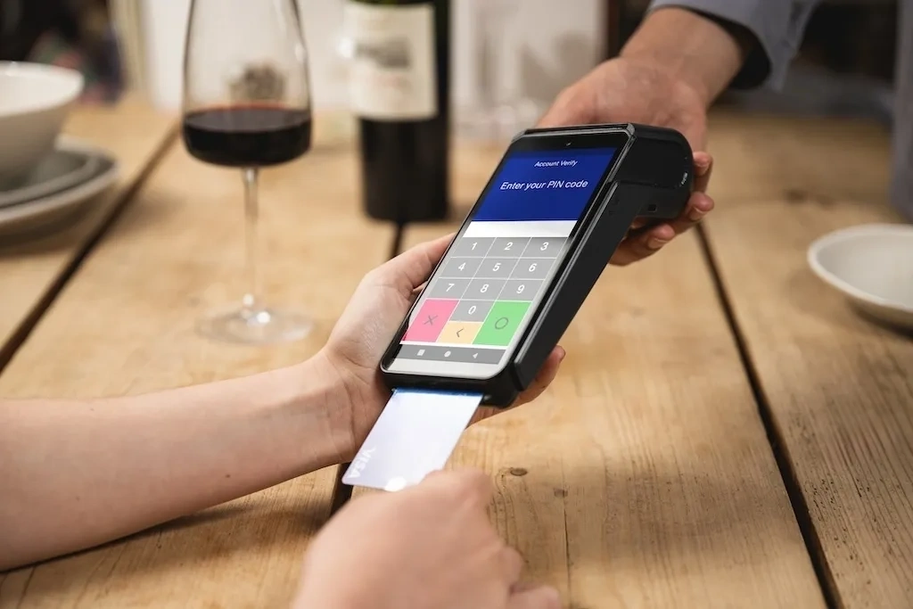 Person using DX8000 card terminal to scan product barcode