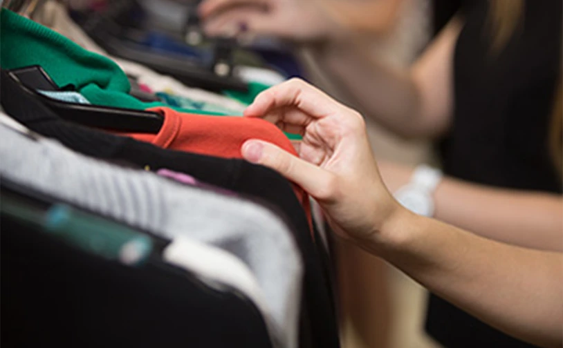 Customer browsing clothing on a rack in a retail store