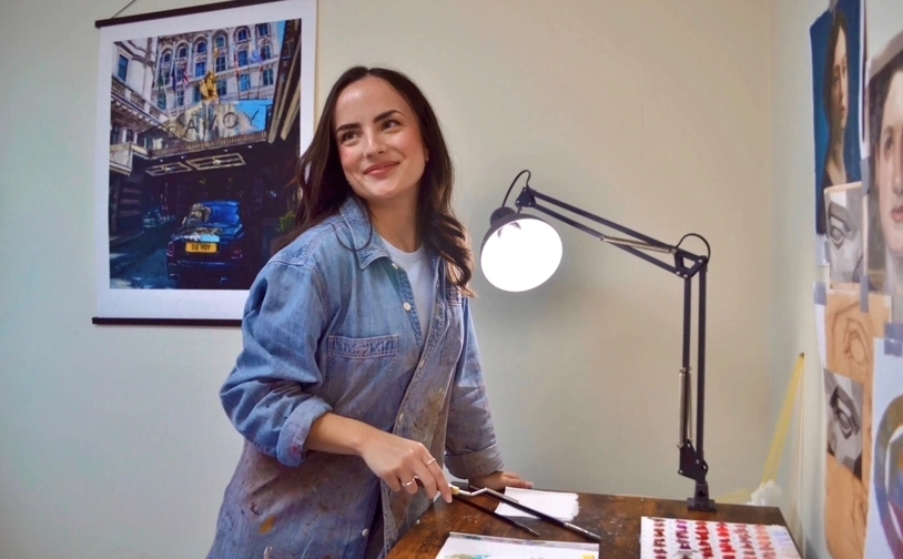 Elysia Gilman standing at her art workstation 