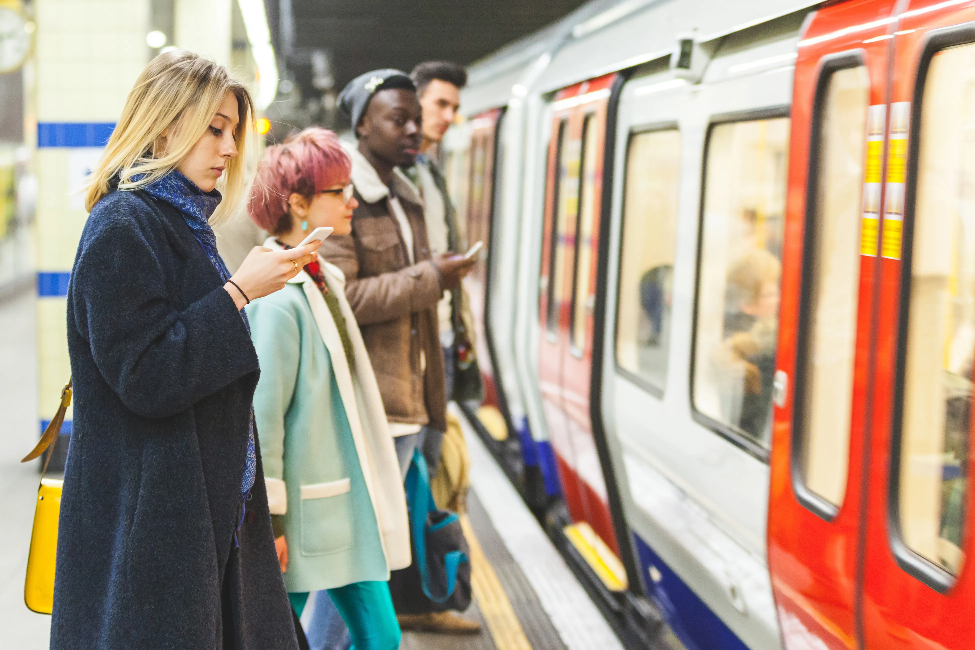 People standing on a station platform, waiting beside a stopped underground train
