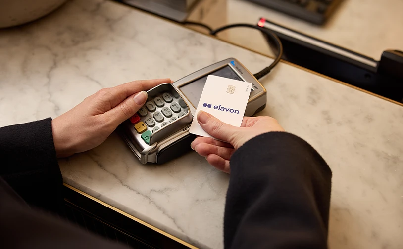 Customer using an Elavon payment card at a card terminal to complete a secure contactless payment transaction at a checkout counter