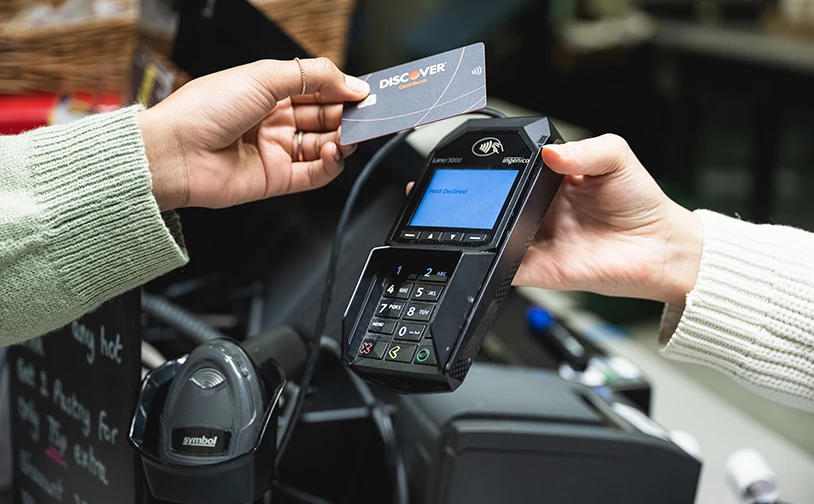 Customer completing a contactless payment at a retail point of sale.