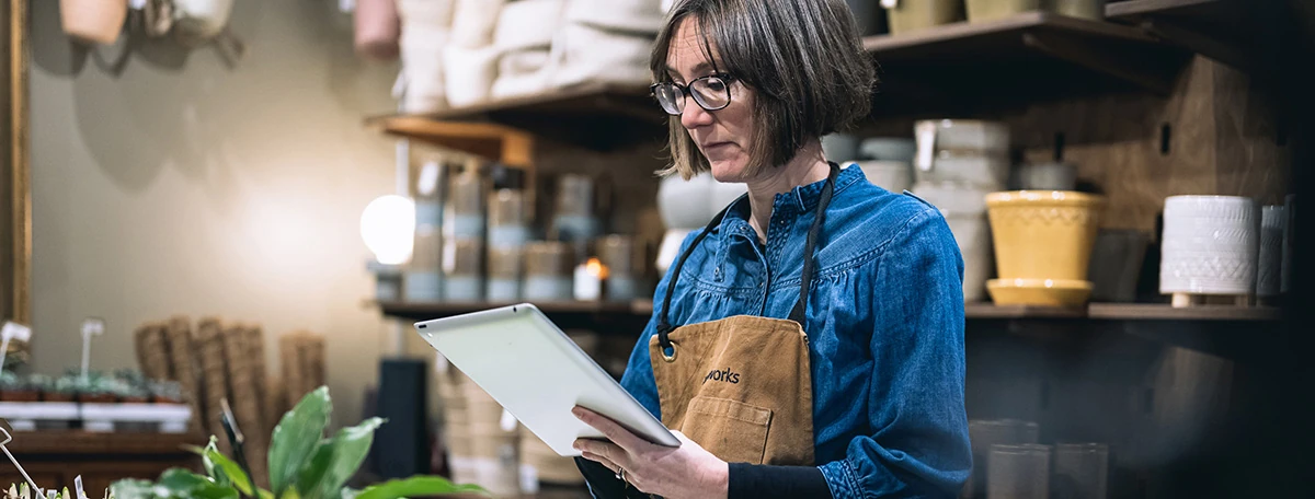 Retail worker using a tablet to manage business operations in a shop