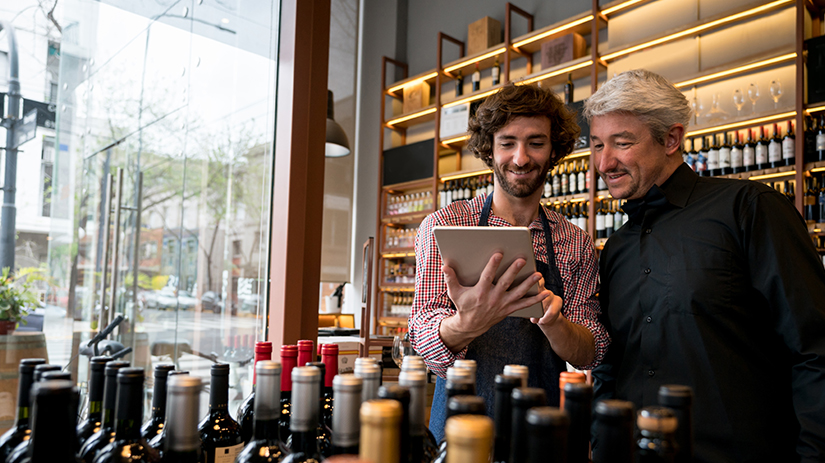 salesman showing a wine app to a customer at a winery